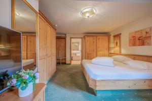 a bedroom with two beds and wooden cabinets at Hotel Rösslwirt in Kirchberg in Tirol +28 photos