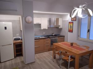 a kitchen with a table and a dining room at Casa Sofia in Agropoli +3 photos