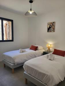 ein Schlafzimmer mit zwei Betten und einem Fenster und einer Lampe in der Unterkunft Alivu bergerie Sotta hyper cosy in Sotta