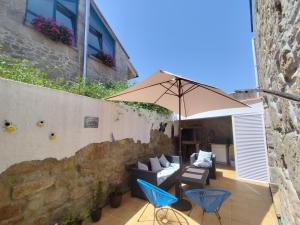 patio z 2 krzesłami i parasolem w obiekcie Casa O Castriño w mieście Cambados