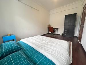 a bedroom with a bed with a blue comforter at Casa Blanca R2 in Cyberjaya