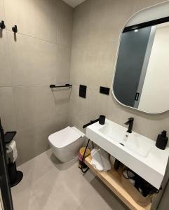 a bathroom with a toilet and a sink and a mirror at Aria Suites Cefalù in Cefalù