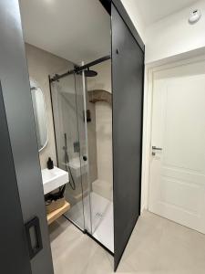 a bathroom with a glass shower and a sink at Aria Suites Cefalù in Cefalù +25 photos