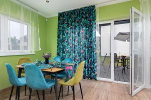 a dining room with a table and blue chairs at Zaciszny Dom HARALD - Taras & Ogrod - Wyspa Wolin by Noclegi Renters in Zastań