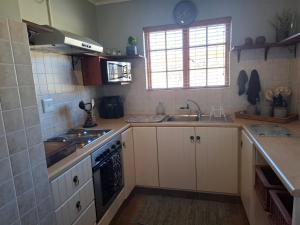 a kitchen with a sink and a stove top oven at Meadow View Guest Cottage in Wakkerstroom