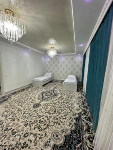 a room with two beds and a chandelier at Guest House NAZIRA in Kazarman