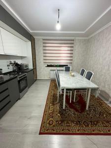 a kitchen with a white table and chairs on a rug at Guest House NAZIRA in Kazarman +45 photos