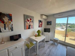 a living room with a desk and a table and a window at Appartement centre-ville climatisé in Cavalaire-sur-Mer +8 photos