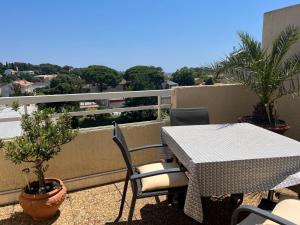a table and chairs on a balcony with a view at Appartement centre-ville climatisé in Cavalaire-sur-Mer