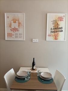 una mesa de comedor con platos y una botella de vino en Casa di Otti, en Ivrea