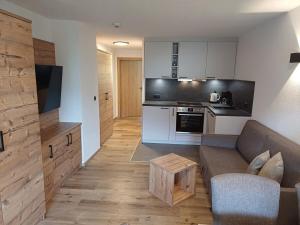 a living room with a couch and a kitchen at Haus Sonneck in Nauders