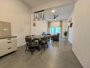 Langkawi IslandsにあるSimfoni Seaview Premium Homestay 08のテーブルと椅子のあるキッチンとダイニングルーム