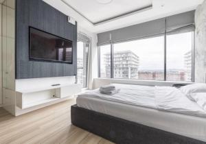 een slaapkamer met een groot bed en een groot raam bij Sweda Apartments Gdańsk Seaside in Gdańsk +149 foto's