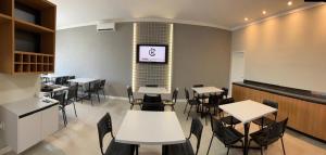 une salle à manger avec tables et chaises et une télévision dans l'établissement Hotel Corporativo Paragominas, à Paragominas 13 autres photos
