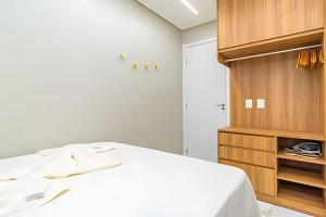 Un dormitorio con una cama y un armario de madera. en Atlantis 312: Luxury and Style Porto de Galinhas, en Porto de Galinhas 48 fotos más