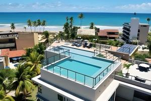 una vista aérea de un edificio con piscina y playa en Atlantis 312: Luxury and Style Porto de Galinhas, en Porto de Galinhas