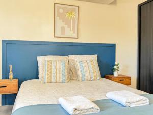 a bed with a blue headboard and pillows at Studio Platanes 8 - Proche Disneyland - Parking gratuit - Meaux in Meaux