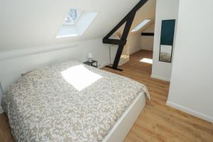 a attic bedroom with a bed and a staircase at Une escale à Malo in Dunkerque