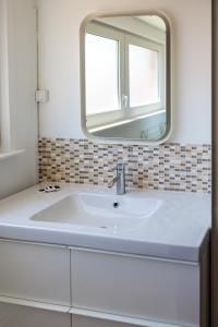 a white sink in a bathroom with a mirror at Une escale à Malo in Dunkerque
