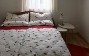 a bed with a white blanket with cherries on it at Haus Schartner Aloisia in Altaussee