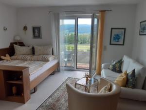 阿特湖Ferienwohnung Mathilde am Attersee的一间带床的卧室和一间带阳台的客厅
