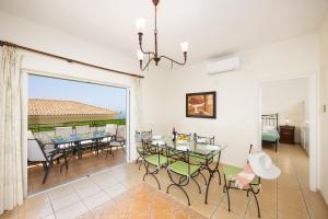 a dining room with a table and chairs and a window at Skala Villa Green in Skala Kefalonias
