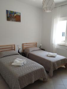 a bedroom with two beds with towels on them at Agorà 1 in Parghelia +10 photos