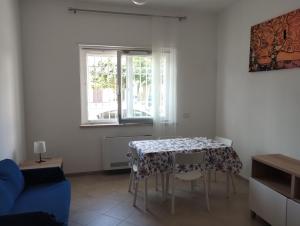 a living room with a table and a blue couch at Agorà 1 in Parghelia