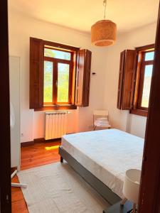 a bedroom with a large bed and two windows at Bam’s Farm in Alcobaça +36 photos