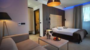 a hotel room with a bed and a couch at Hotel Gallus in Sesvete