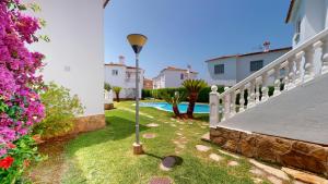 a yard with a light pole in the grass at Peony by ON Travel in Oliva