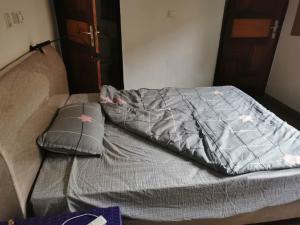 亚穆苏克罗Residence WULIAN的床上铺有灰色的被子