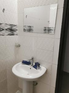 亚穆苏克罗Residence WULIAN的一间白色浴室，配有洗手池和镜子。