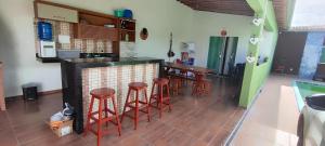 a kitchen with a counter and stools in a room at Casa com dois quartos e piscina in Barreirinhas