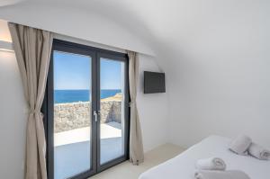 a bedroom with a window with a view of the ocean at San Nectar Luxury Villas in Vourvoulos +52 photos