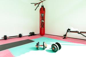 a gym with dumbbells and a punching bag at Villa Pantai - Signature Property in Gili Air