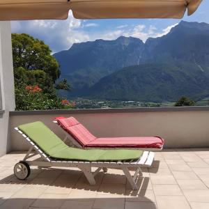 a lounge chair on a balcony with a view of mountains at La PERLA di LEVICO in Levico Terme +19 photos