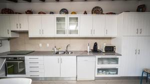 a kitchen with white cabinets and a sink and a microwave at Monte dos Casarões Casa grande in São Luis