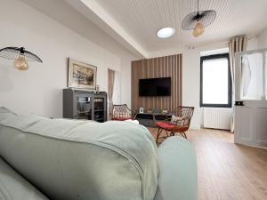 a living room with a couch and a tv at Charmante maison proche village Vendée Globe - 6 personnes in La Chaume