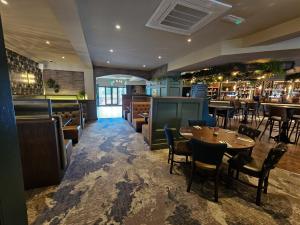 a restaurant with tables and chairs and a bar at Hotel Nineteen in Barnsley