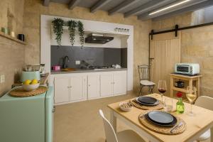 a kitchen with a table with plates and wine glasses at Un Quarto di Torre in Tarquinia