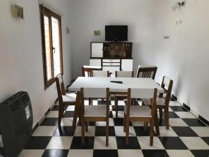 una sala da pranzo con tavolo e sedie su un pavimento a scacchi di La Rioja 4880 n1 a La Lucila del Mar