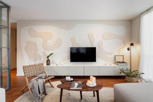 un soggiorno con una TV a schermo piatto su una parete di Java - 3 bedroom and shared pool in Almagro a Madrid