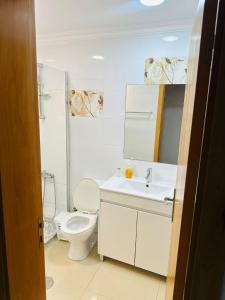 a white bathroom with a toilet and a sink at jotapecomercio in Praia