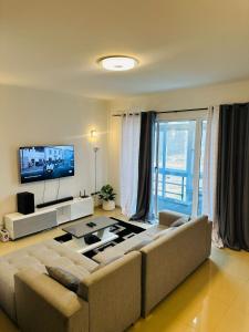 a living room with a couch and a flat screen tv at jotapecomercio in Praia