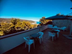 a balcony with tables and chairs and a view of the ocean at Conte Cavour B&B in Peschici
