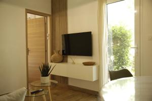 a living room with a television and a table and a window at Le patio d'Elio, Arcachon in Arcachon