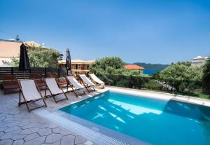 a swimming pool with chaise lounge chairs next to a swimming pool at Melodia Lefkada Apartment 3 in Nikiana