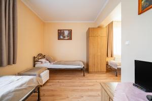 a small room with two beds and a tv at Pokoje u Beaty in Zakopane