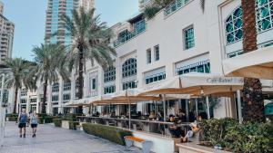 personnes marchant sur un trottoir devant un bâtiment dans l'établissement Luxurios One Bedroom High Floor, à Dubaï